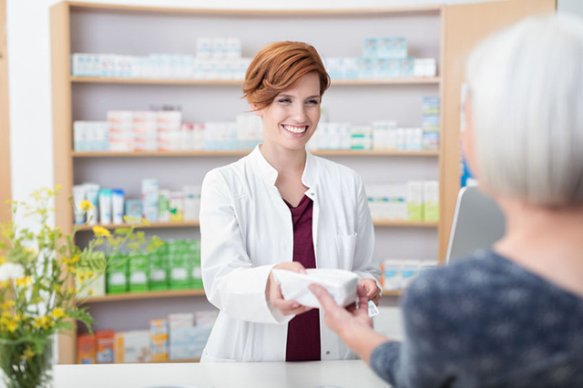 Image of a pharmacist handing an item to a patient