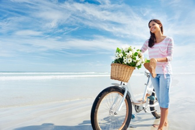 Beach image of woman with bicycle