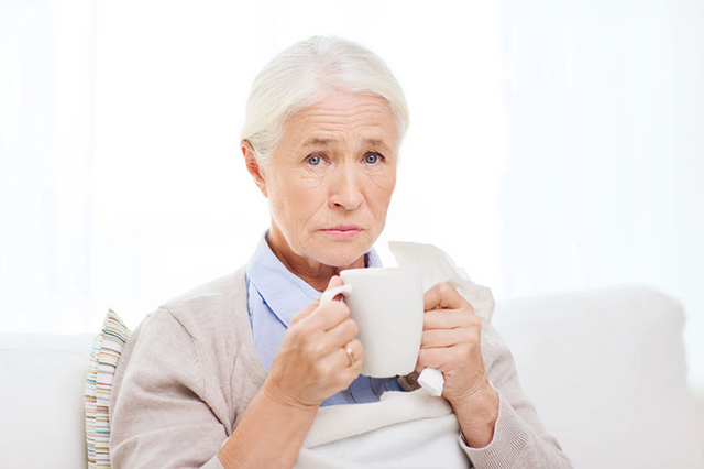 Image of older lady holding a mug drinking from mug. Block on Access to medicaation for patients with symptoms of Covid nineteen.